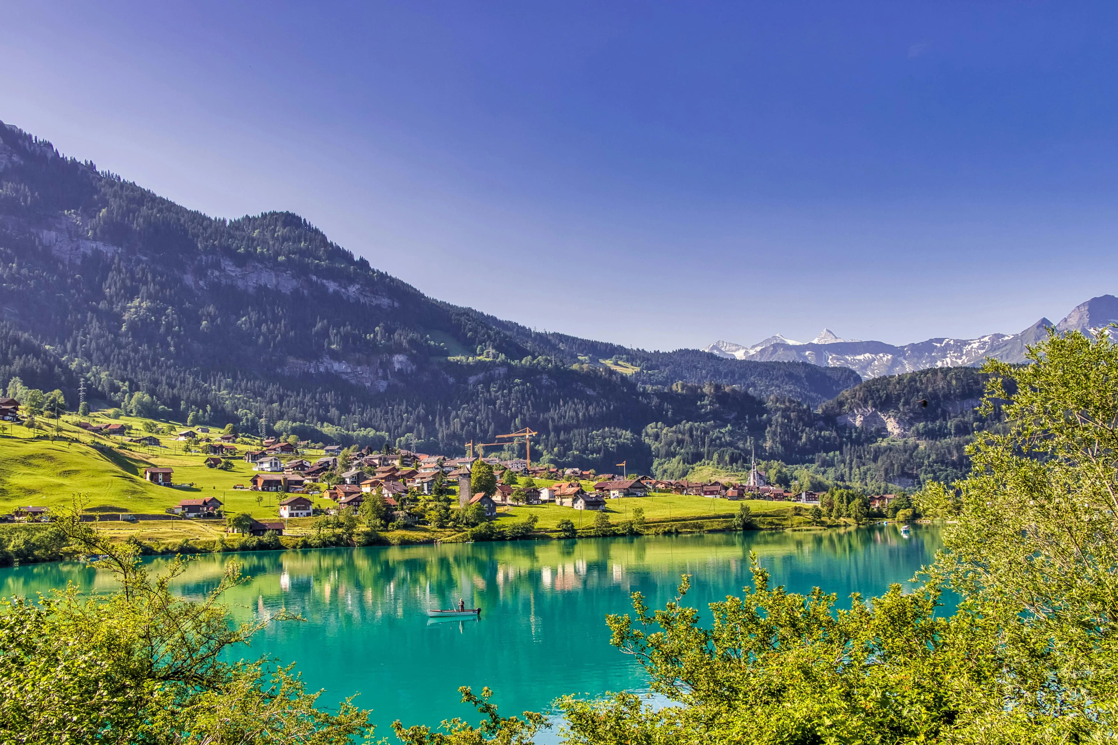 Crystal-clear Swiss alpine lake surrounded by green mountains and a village