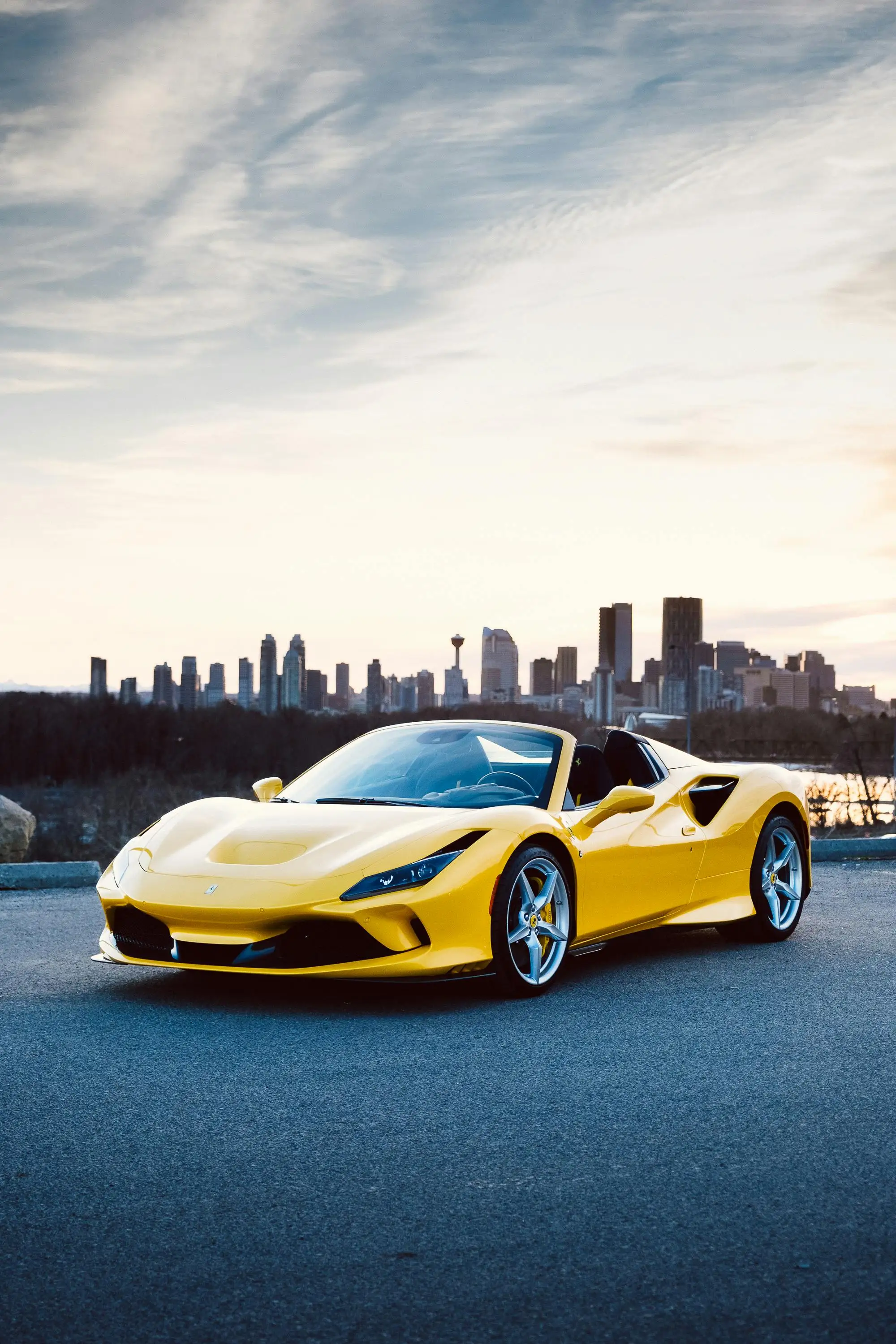 Yellow Ferrari F8 Spider convertible against dramatic sky
