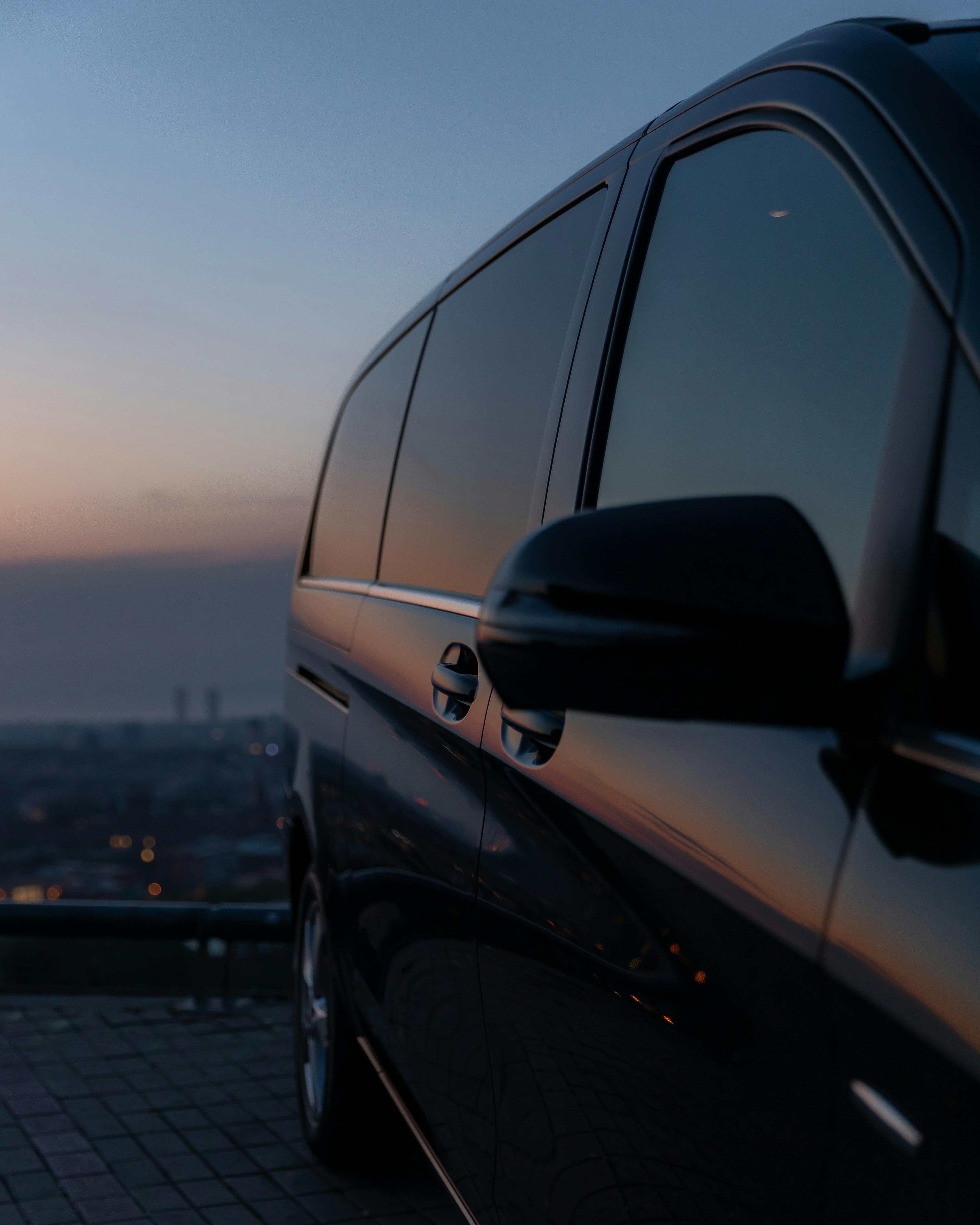 Mercedes V-Class side profile at sunset with city lights in the background